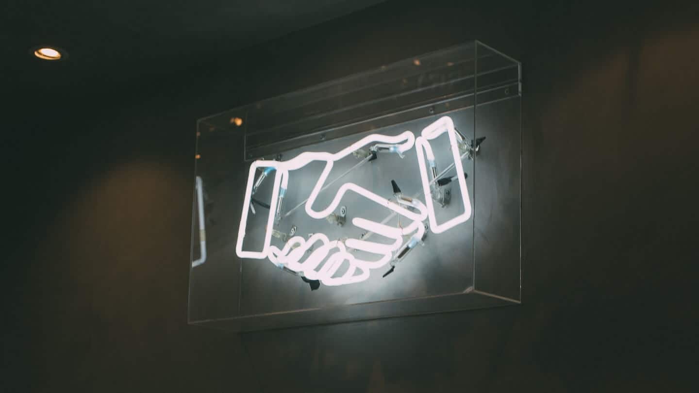 Photo d'une poignée de mains en néons
